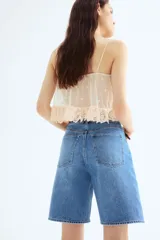 Bermuda de denim celeste, de tiro alto, corte recto y cinco bolsillos.