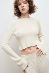 Sweater color crema de punto, confeccionado en 100% algodón, con diseño ligero y corte femenino.