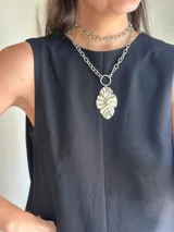 Collar plateado de doble cadena con dije colgante con forma de hoja.