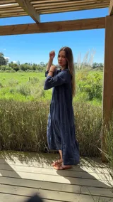 Vestido largo azul marino de lino con cuello mao, escote en V, mangas 3/4 con volados y corte escalonado. Diseño amplio y cómodo.