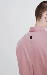 Camisa manga larga color rosa, de calce oversize, con bolsillo con ojal y botón en el delantero.