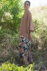 Vestido largo color camel, con escote en V, mangas amplias y estampa de un tigre con flores en la falda.