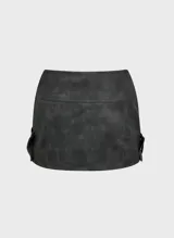 Minifalda negra de cuero sintético con cierre frontal con cremallera y cintas cruzadas con hebillas metálicas.