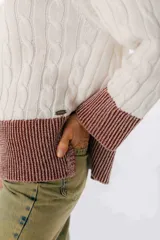 Sweater color camel con tejido de trenzas y terminaciones en color beige.