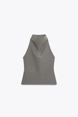 Top gris de cuello halter con botones en la nuca y espalda descubierta. Cierre lateral con cremallera oculta.