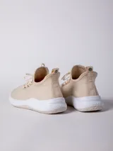 Zapatilla de textil color beige, con diseño de calce tipo media y suela bicolor de 4 cm.