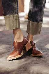 Zapatos de cuero color marrón con puntera fina, detalle de textura en el empeine, diseño slip-on y suela dentada.