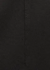Pantalón negro ajustado al cuerpo, de tiro alto y largo tobillero.