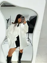 Camisa oversize color beige de manga larga con bolsillos frontales.