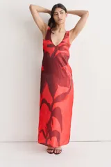 Vestido largo de seda con estampado floral abstracto en blanco sobre fondo negro, escote redondo y corte recto.