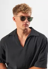 Gafas de sol Eco Shades Fontana con montura redonda gris y lentes verdes. Fabricadas con acetato biodegradable y lentes de PMMA reciclado.