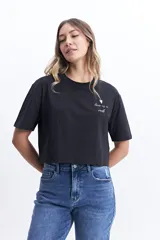 Remera corta color verde lima con estampado frontal de un corazón y la frase "love is a verb".