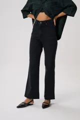 Pantalón de jean negro de tiro alto, corte flare y pretina con trabillas. Confeccionado en denim 100% algodón.