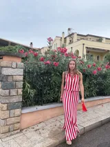 Falda larga tejida a rayas rojas y blancas, con pretina elástica y tajos laterales profundos.