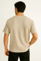 Remera manga corta color verde militar, de tejido waffle con bolsillo en el pecho y cuello redondo.