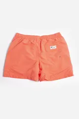 Short de baño liso color azul con cintura elástica ajustable con cordón, bolsillos laterales, tela ligera de secado rápido, suspensor interno y logo estampado.