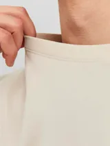 Camiseta color beige de manga corta y cuello redondo con fit relajado. Estampado en relieve con la inscripción "Originals Studio".