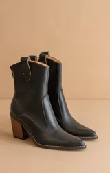 Botín negro de cuero sintético con puntera fina, caña media y tacón de madera.