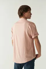 Camisa lisa color salmón con cuello mao y mangas cortas con dobladillo.