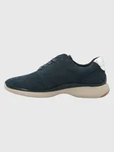 Zapatillas Hush Puppies modelo Goss, color azul marino, confeccionadas en cuero, con detalles metalizados en el talón y cordones. Suela de EVA con tecnología Zero G y plantilla Bloom de algas recicladas.