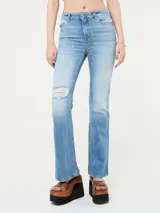 Pantalón de jean de tiro alto, corte ajustado y botamanga acampanada. Presenta roturas en la parte delantera.