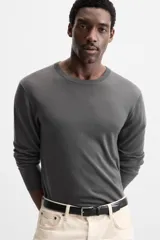 Jersey negro de lana con acabado mercerizado, corte relaxed fit, cuello redondo y manga larga con terminaciones en rib.