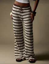 Pantalón de tejido crochet a rayas horizontales marrones y crudas, de corte recto y cintura con cordón ajustable.