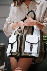 Mochila de cuero vacuno con compartimiento general y múltiples bolsillos, incluyendo dos exteriores con tapa y cierre.