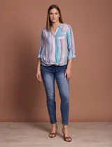 Blusa estampada con cuello a la base, escote en V y botones. Delantera con bolsillo aplicado. Largo de manga regulable con presilla y botón. Terminación anudada opcional.