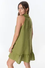 Vestido corto color ladrillo, sin mangas, con cuello camisero con volados, abotonado al frente y falda con volados.