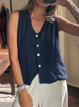 Chaleco sin mangas color azul marino, con escote en V y cierre frontal de botones blancos.