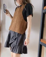 Chaleco color crema de cuero agamuzado con espalda cruzada.