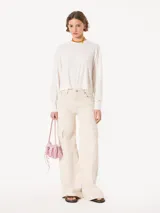 Sweater tejido suave y flojo, color crudo, con cuello redondo y mangas largas.