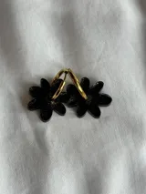 Aros colgantes plateados con dije de flor acrílica color dorado.