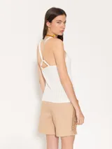 Top blanco de punto con breteles finos y escote redondo. Tejido con textura acanalada vertical.