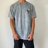 Remera gris con efecto acid wash y estampado en el pecho de una pelota de baloncesto con llamas y texto.