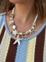 Collar corto con cuentas de nácar en diferentes formatos, perla natural XL y medallón de resina. Se cierra con cadena de acero quirúrgico y ganchito para regular el largo.