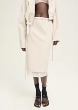 Falda midi color crudo, de corte recto y tiro medio. Presenta un forro interior visible de ramio y cintura con goma elástica.