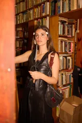 Chaleco de cuero color marrón con textura de piel sintética, bolsillos delanteros con solapa y cierre frontal mediante lazo de cuero.