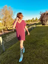 Vestido corto fucsia tejido en lurex metálico con escote en V y mangas cortas.