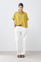 Camisa color pistacho de lyocell con cuello clásico, cierre frontal con botones y mangas cortas.