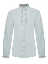 Camisa celeste de denim confeccionada en 100% Tencel, con cuello alto con volado, frente de botones con pequeños volados y puños con volado.