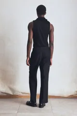 Musculosa negra de punto acanalado, corte ajustado, cuello redondo y sisas con ribete fino.