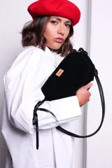 Cartera tipo sobre color bordó, confeccionada en PU tipo gamuza, con correa regulable de nudos chunky y cierre superior.