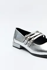 Zapato tipo Mary Jane color negro con textura de reptil, de charol sintético con punta cuadrada y triple tira con hebillas.