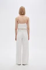 Pantalón jean de calce ancho y tiro alto, con diseño color block en tonos blanco y beige.