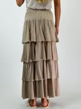 Pollera larga color beige con cintura elastizada y corte escalonado con volados.