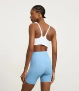 Conjunto deportivo de dos piezas, color fucsia vibrante, compuesto por un top deportivo de escote redondo y una bermuda ciclista de tiro alto.