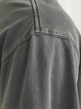 Camiseta gris oscuro de manga corta con cuello redondo y estampado blanco en el pecho.