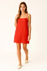 Vestido corto de algodón con breteles finos ajustables y escote cuadrado. Presenta tejido broderie con pequeños calados verticales.